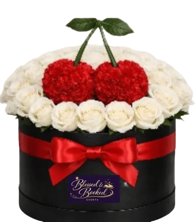 Decorative box with white flowers, red cherries, and a red bow, featuring 'Blessed & Booked' on a white background.